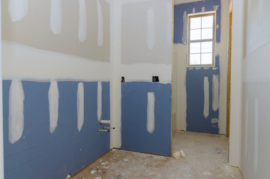 A newly constructed house is in the process of being plastered and the drywall is ready for painting